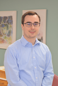 MKL Orthodontists staff member smiling in a professional headshot wearing a light blue shirt and glasses