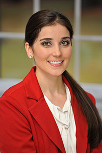 Dr. Lamb, orthodontist at MKL Orthodontists, smiling in a professional headshot wearing a red blazer