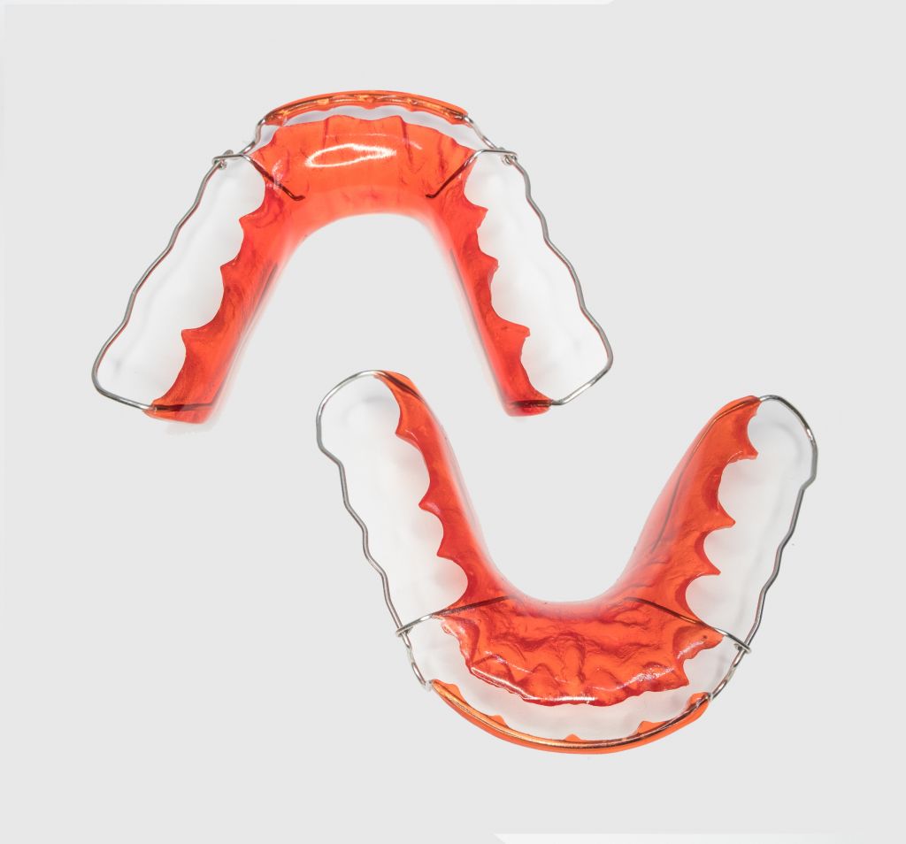 Upper and lower Hawley orthodontic retainers with red acrylic and metal wire